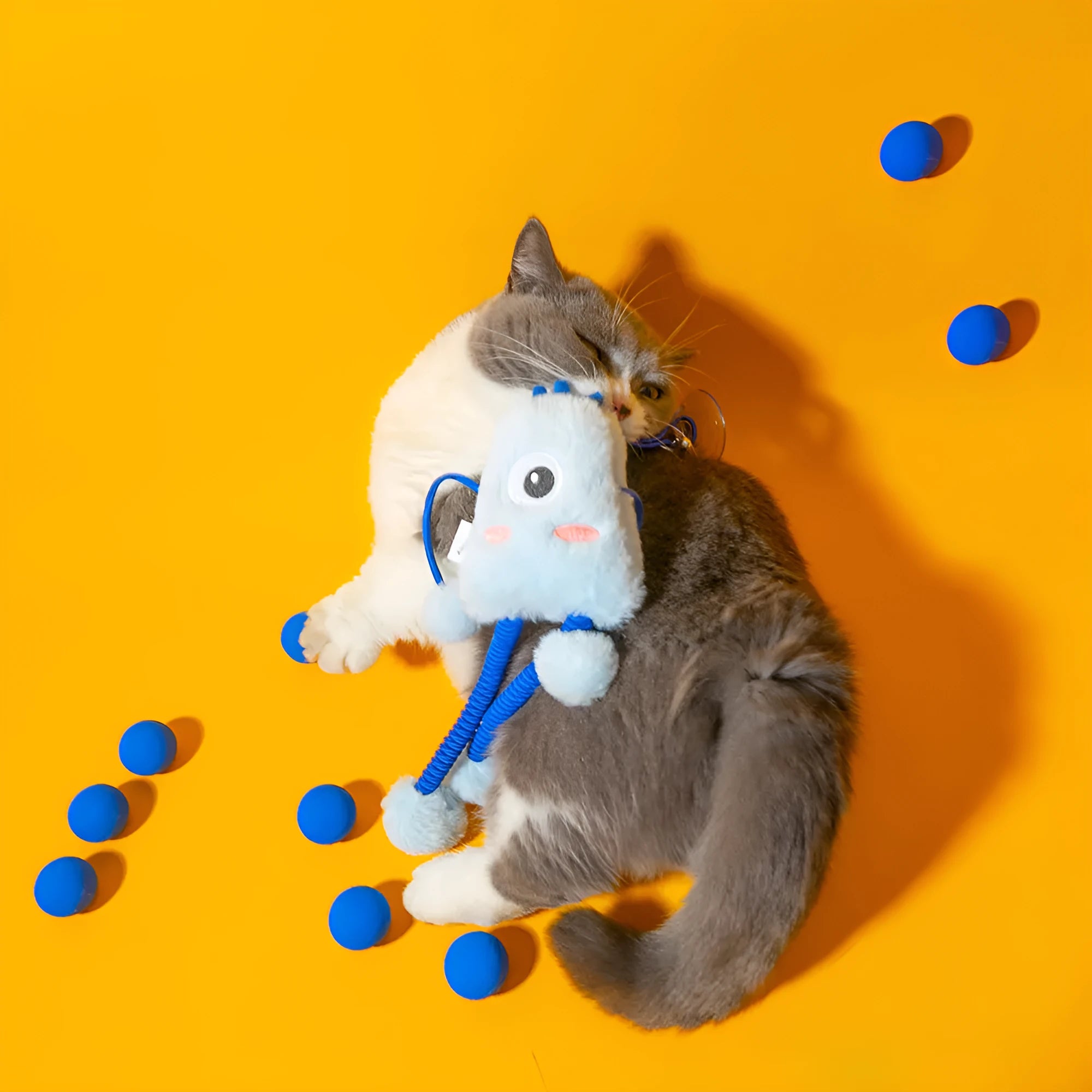 Blue plush cat toy with telescopic elastic rope, ring with bell and mint element on white background