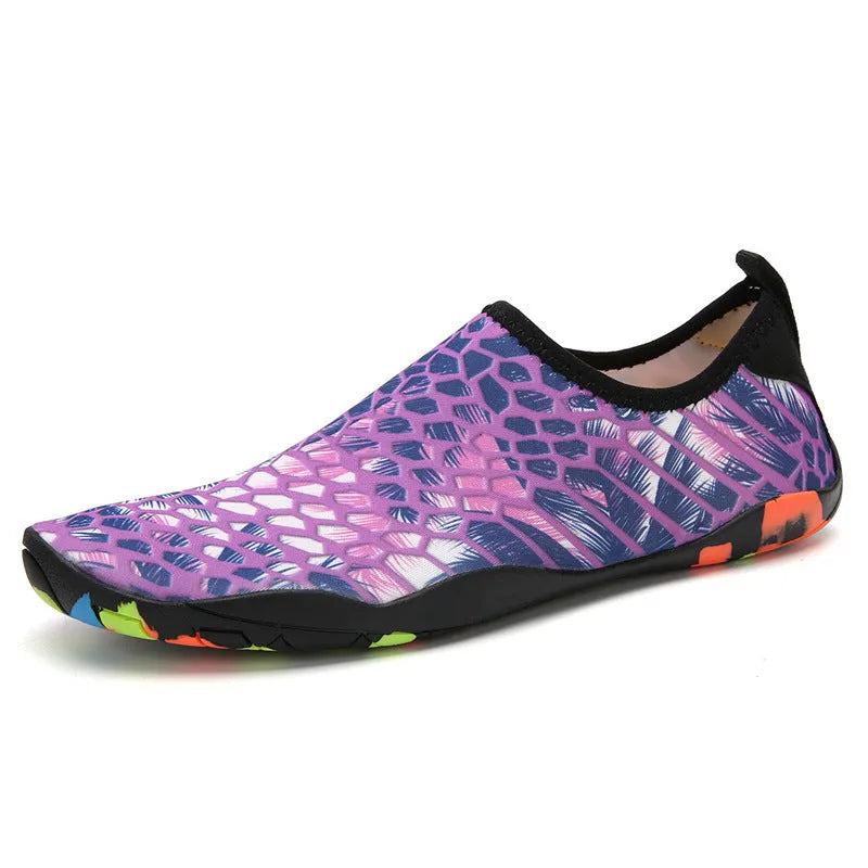 Blue and camouflage coloured beach wading shoes with Lycra uppers on a sandy background