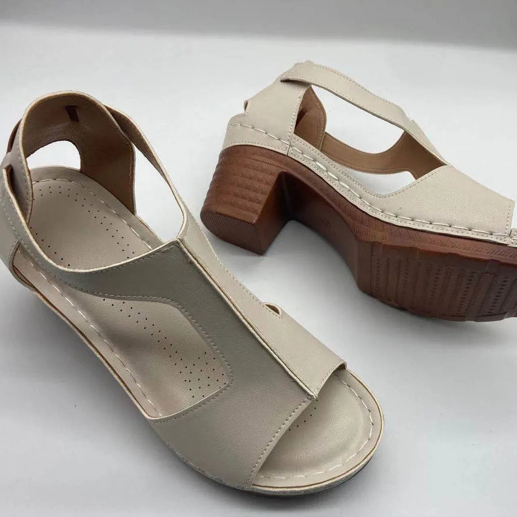 Women's white peep toe wedge sandals with a Roman-style buckle strap and low heel.