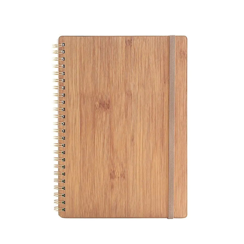 Open erasable coil notebook with stone paper pages, a pen, and a wipe cloth on a desk.