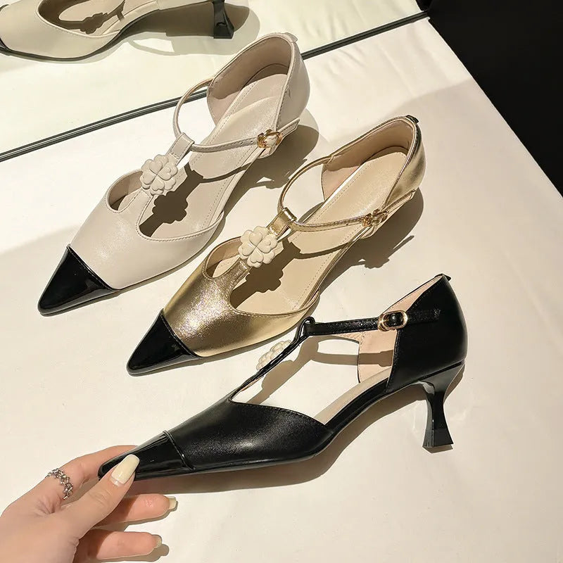 Women's black stiletto heel shoe with pointed toe, floral buckle detail, and a mid-height heel