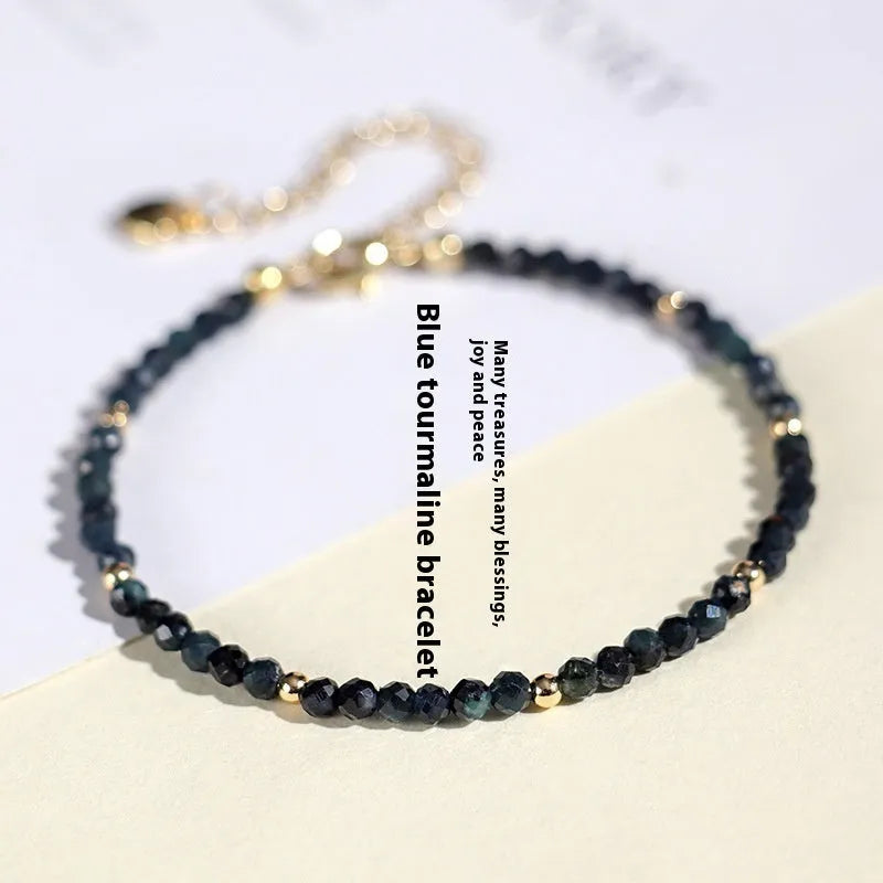 Close-up of a blue tourmaline bracelet with 3mm cut beads and spacer beads.
