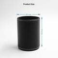 Round black leather pen holder on desk with pens
