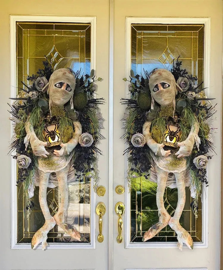 Three-dimensional mummy Halloween wreath with skeleton hands on a wooden door