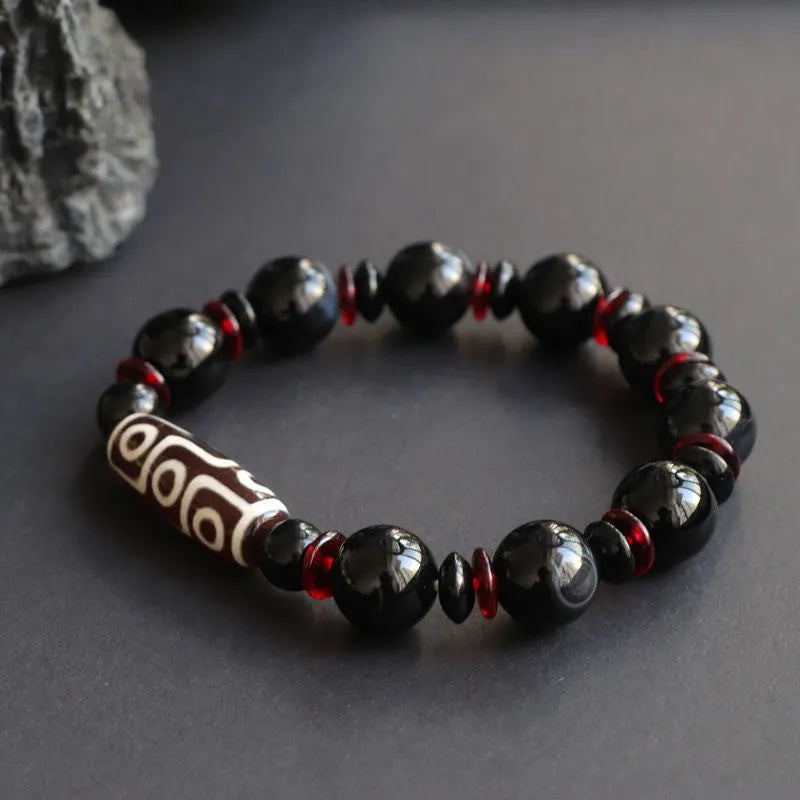 Hand-woven black agate Dzi bead bracelet with 11mm geometric beads on a wrist