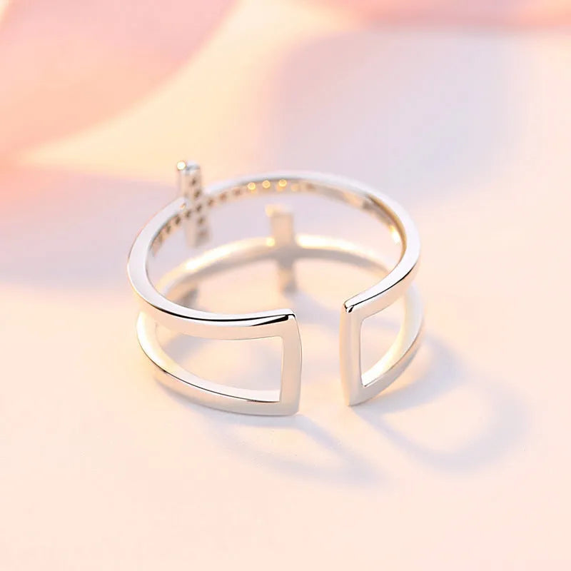 Adjustable double cross geometric ring in copper with cubic zirconia stones, shown in a gold colour finish.