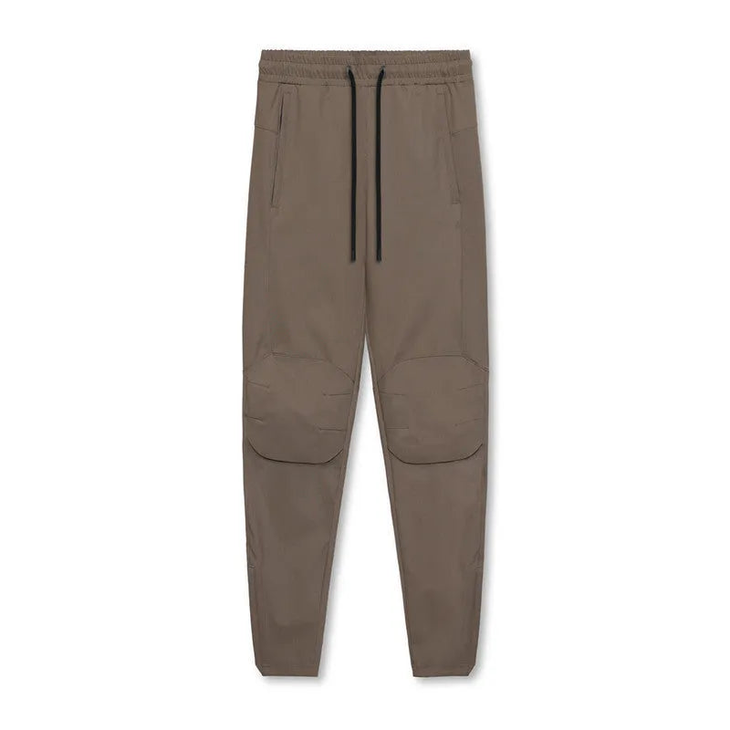 Men's grey quick-dry fitness pants with ankle ties shown in loose fit for exercise
