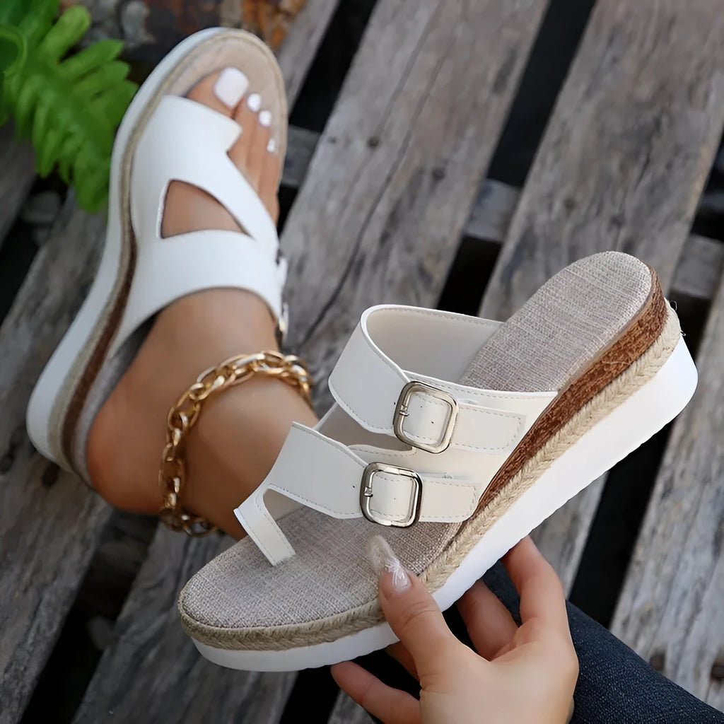 White wedge heel sandals with woven patent leather upper and peep toe design