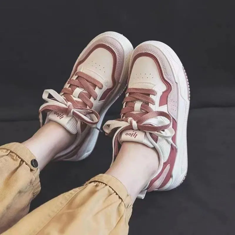 Pink and white low-top sneakers with rubber soles and imitation leather lining