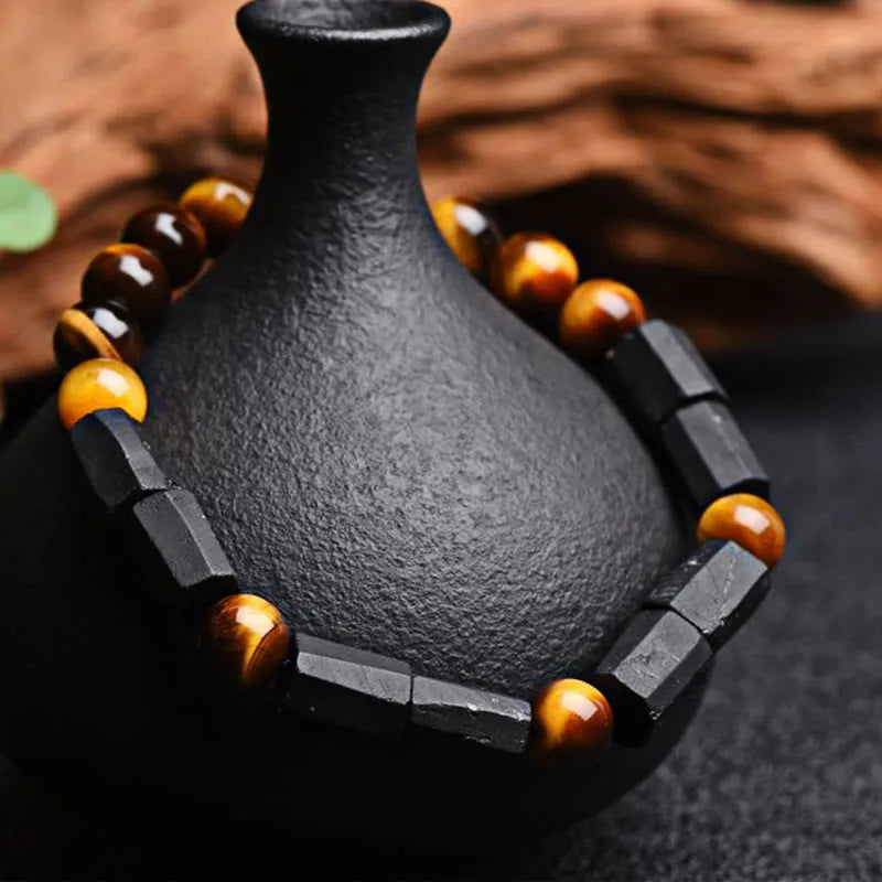 Natural obsidian single ring 8mm beaded bracelet in gold obsidian style on a plain background