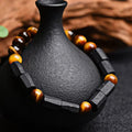 Natural obsidian single ring 8mm beaded bracelet in gold obsidian style on a plain background