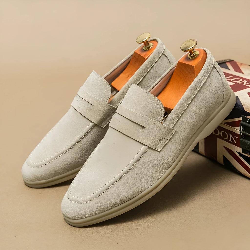 Men's black leather slip-on shoes with round toe and rubber soles shown from side view