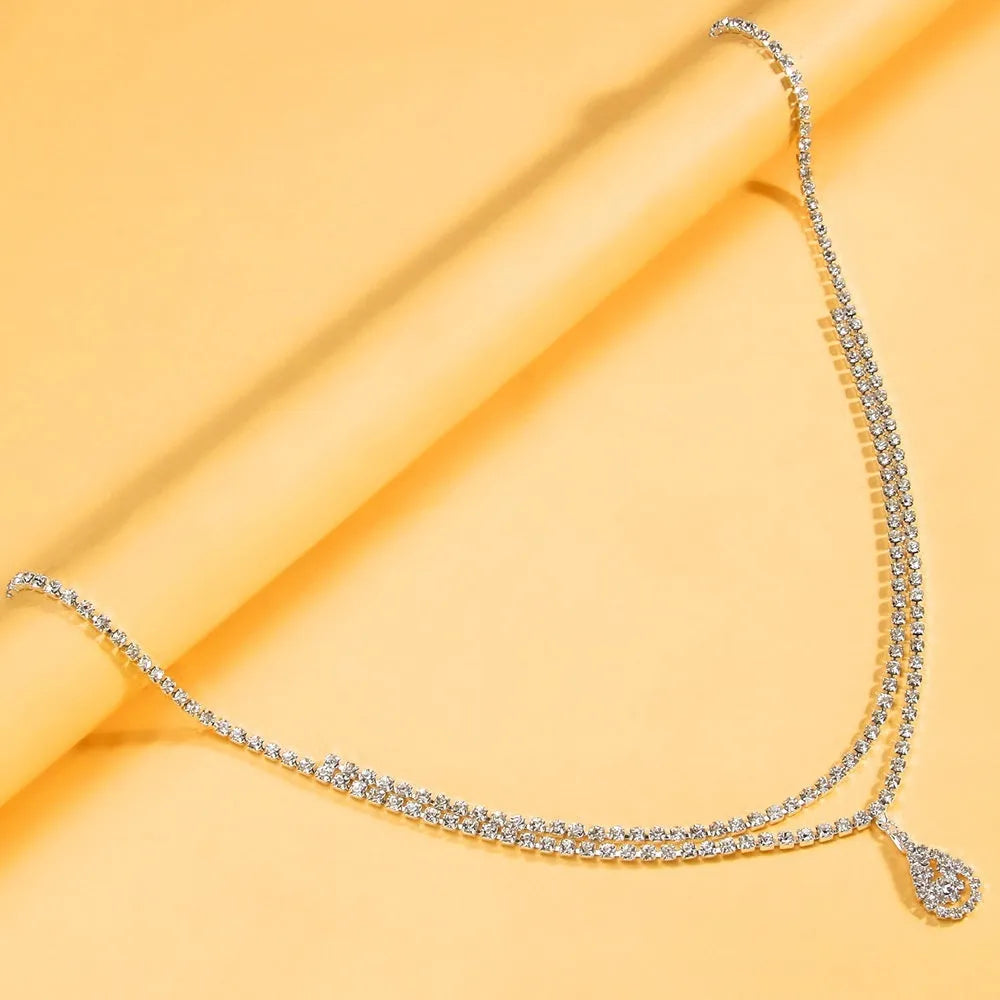 Gold or silver waist chain with water drop pendant and tassel detail, showing lobster clasp closure.