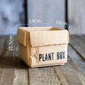 Cement flowerpot with brown paper box design and drainage holes for indoor planting