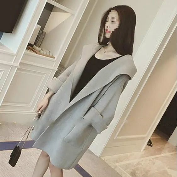 Plus size woman wearing a loose-fitting thin gray coat with long sleeves and lace detail.