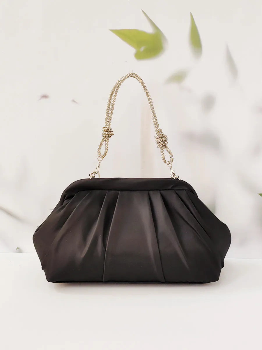 Women's black shell shape crossbody bag with diamond pattern and chain details showing internal document compartment
