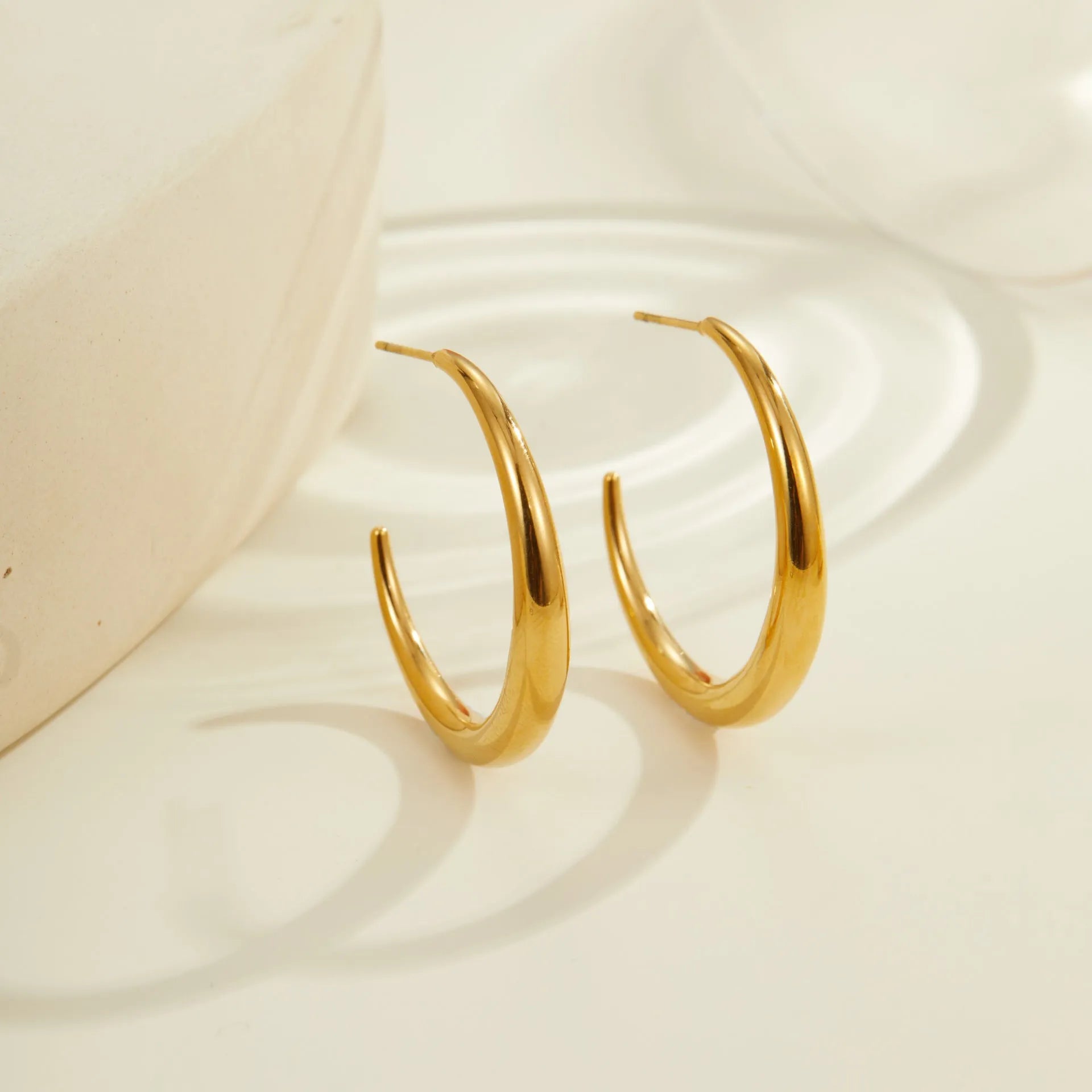 Geometric round titanium steel hoop earrings with 18K gold plating in large and small sizes