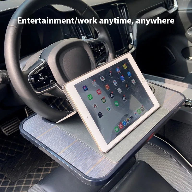 Black car steering wheel laptop tray mounted on vehicle steering wheel with laptop placed on surface