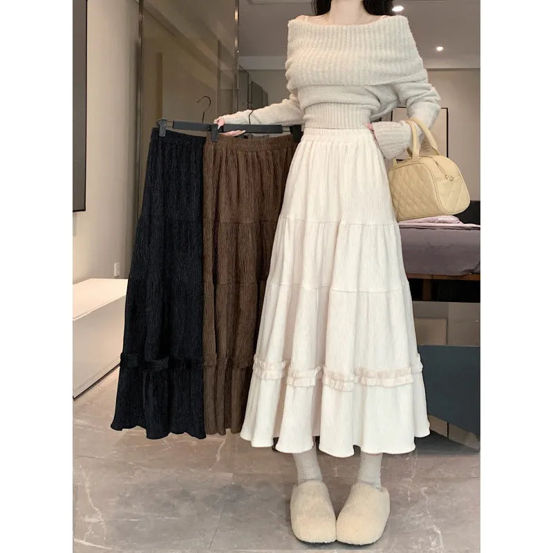 Solid colour corduroy A-line midi skirt with an elastic waistband, shown in a neutral colour.