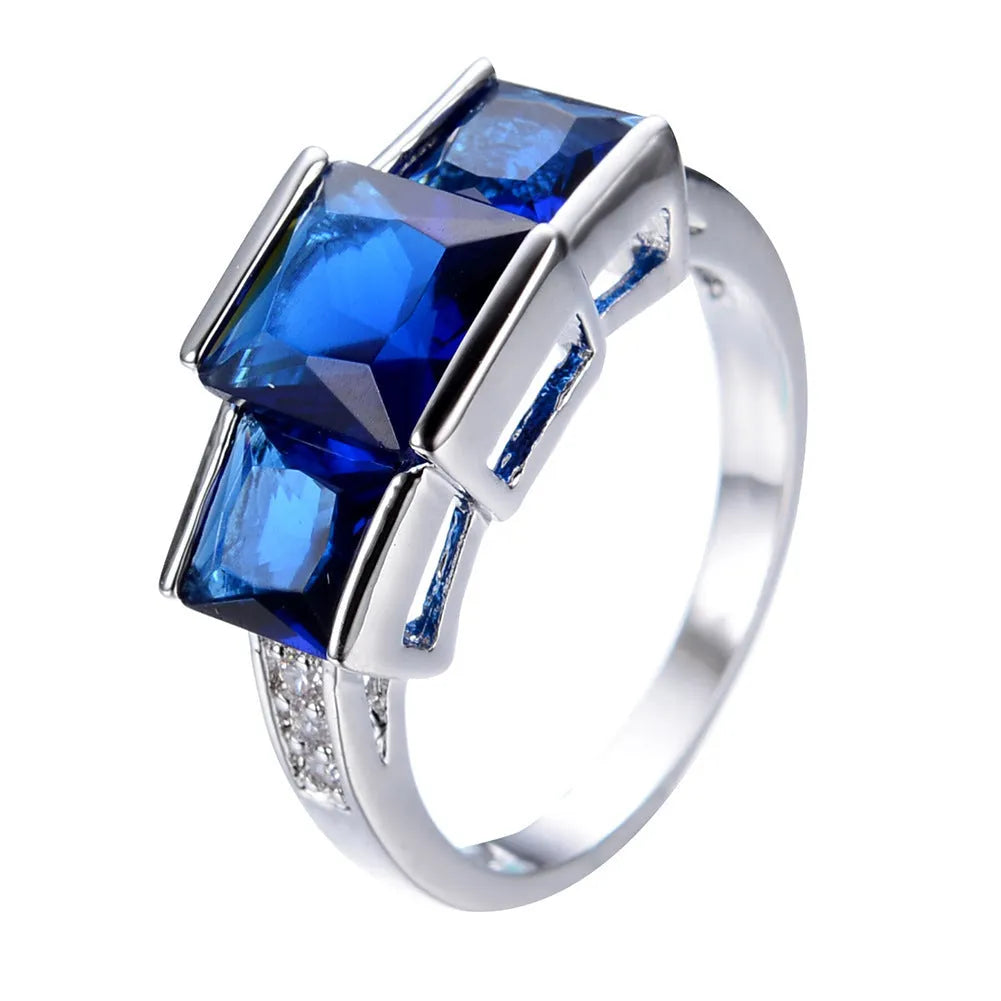 A selection of colourful electroplated copper rings in geometric designs, showing various sizes and hues.