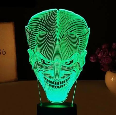 USB-powered 3D acrylic LED lamp showing seven colour options and remote control on a desk.