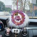 Handwoven wool bell orchid car pendant in green, hanging from a rear-view mirror.