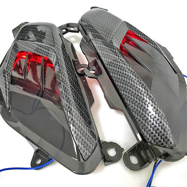 Pair of YAMAHA NMAX motorcycle LED side lamps with ABS shell on a white background