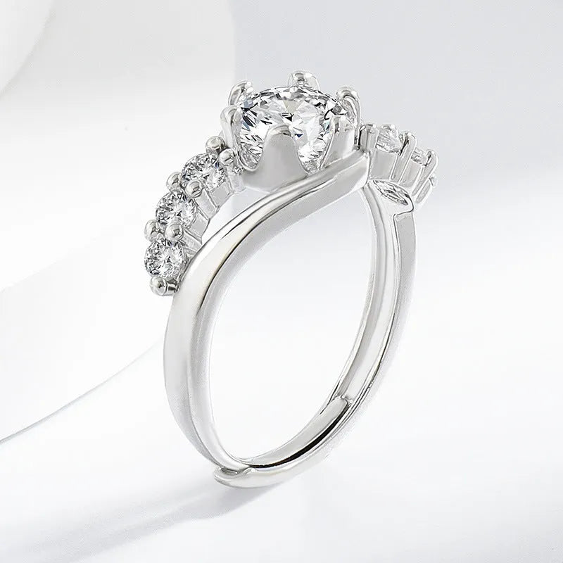 White gold colour crown-shaped copper ring on a plain background