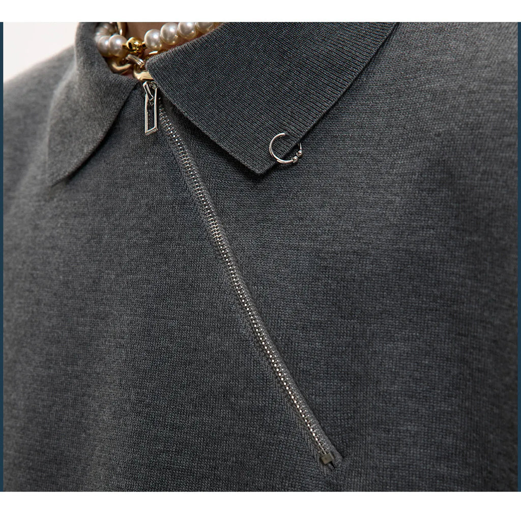 Man modelling a slim-fit black knitted polo shirt with an oblique diagonal zip closure and short sleeves.