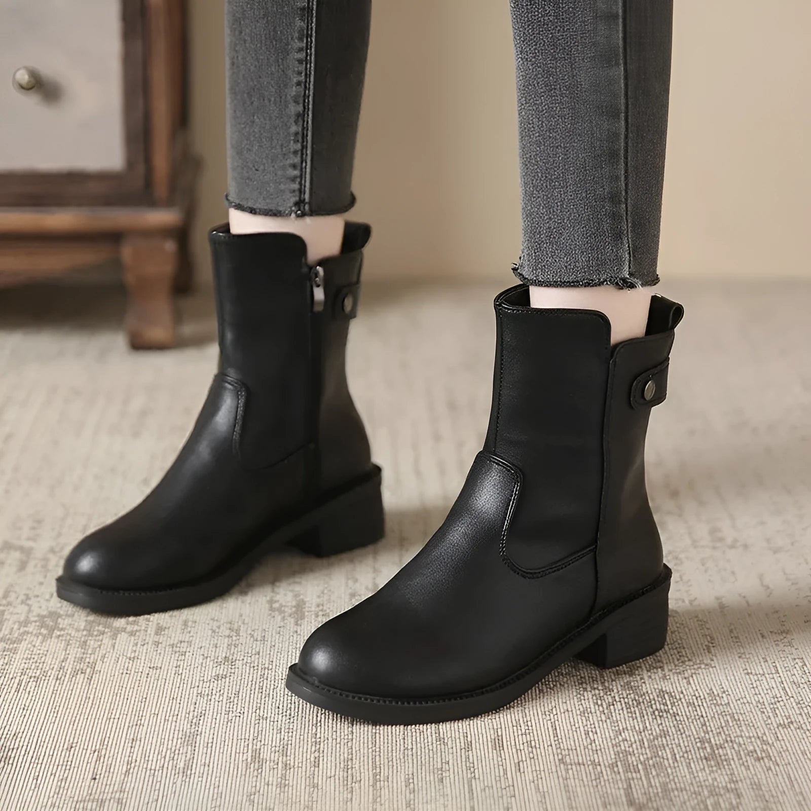 Black women's short boots with a side zip, round toe, and low rubber heel on a neutral background.