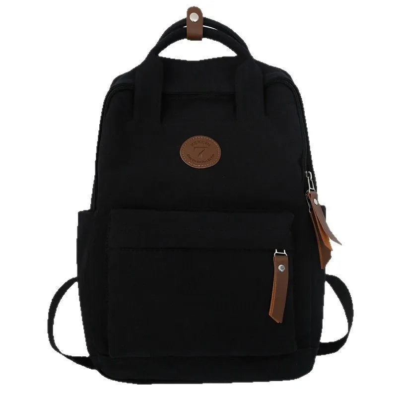 Solid black Oxford cloth fashion backpack with retro sewing thread details and curved shoulder strap for school and travel.