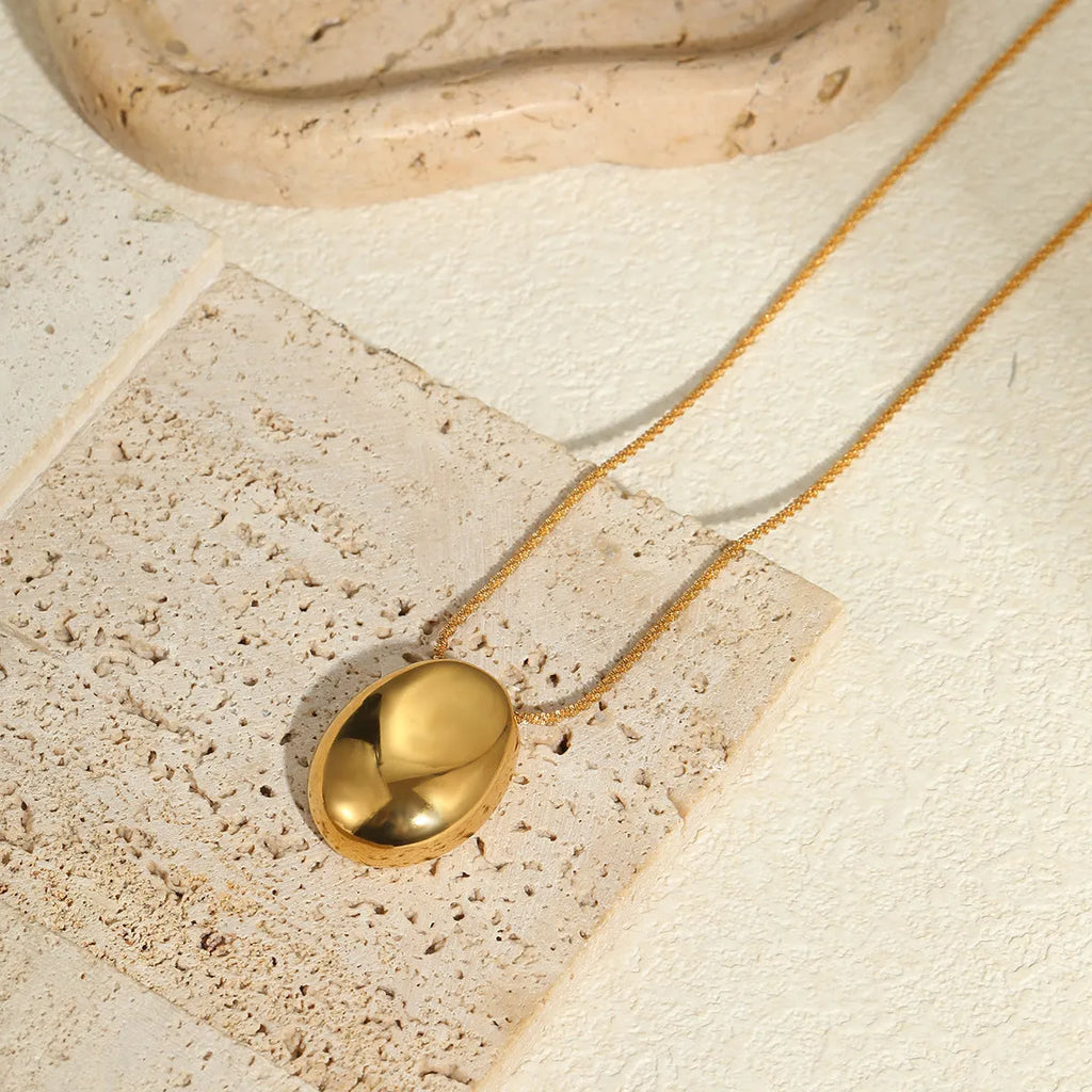Gold-plated necklace with geometric pendant on stainless steel chain, showing 18K plating and adjustable length