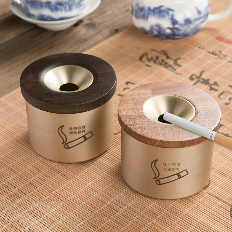 Retro brass and copper ashtray with wooden lid on a living room table.
