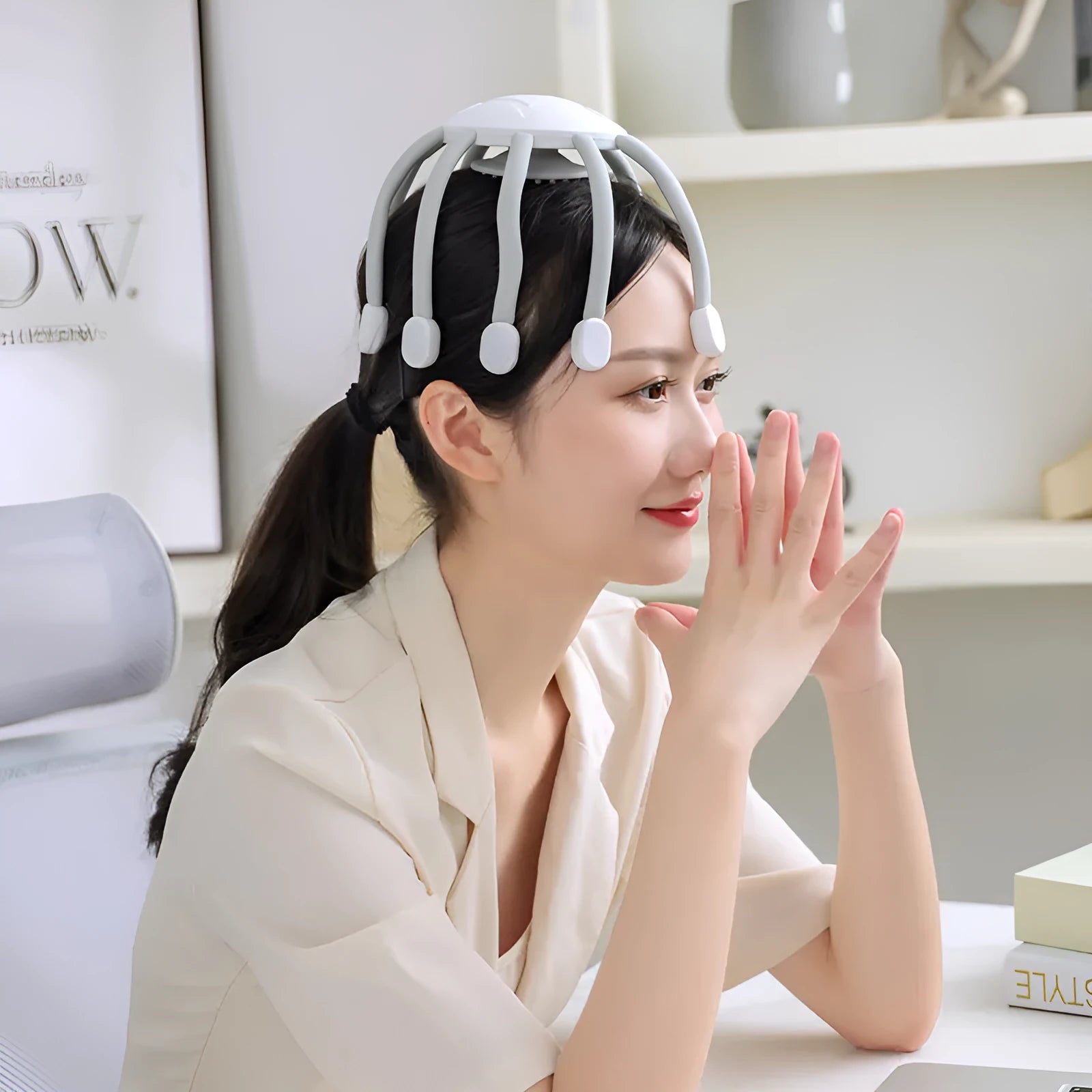 Black or white electric head massager with multiple plastic claws for scalp vibration and relaxation.