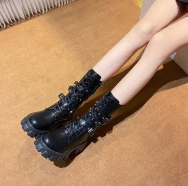 Women's black mid-calf buckle boots with side zipper and round toe on wooden floor