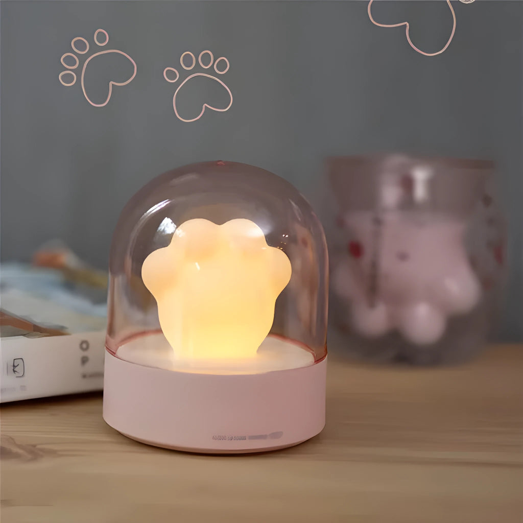 Grey cat paw shaped musical night light with USB charging cable on wooden desktop