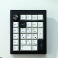 Black and white wireless Bluetooth mechanical numeric keyboard on a desk.