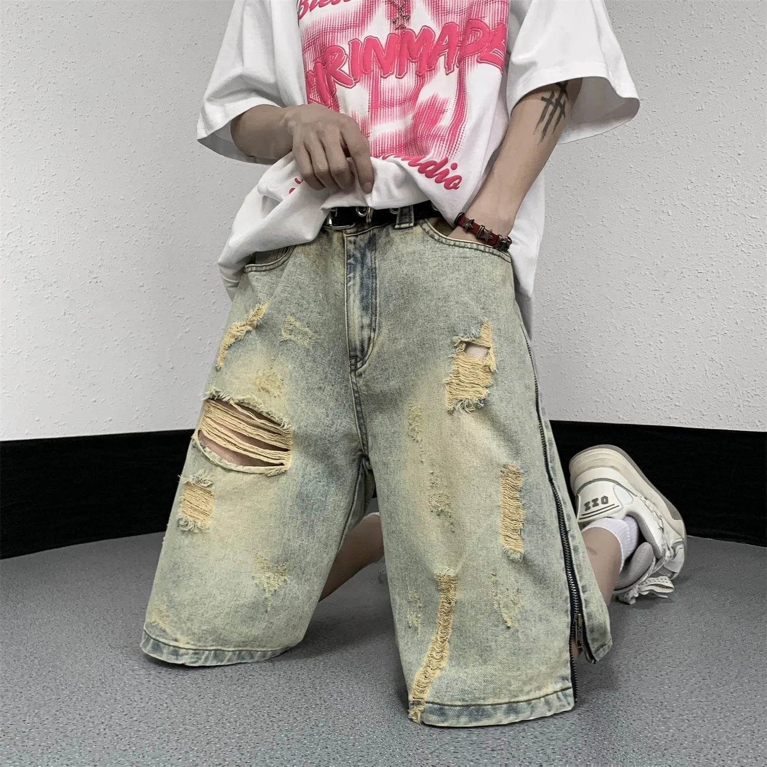 Men's blue denim shorts with loose five-point cut and yellow mud ripped detailing, button fly, straight leg