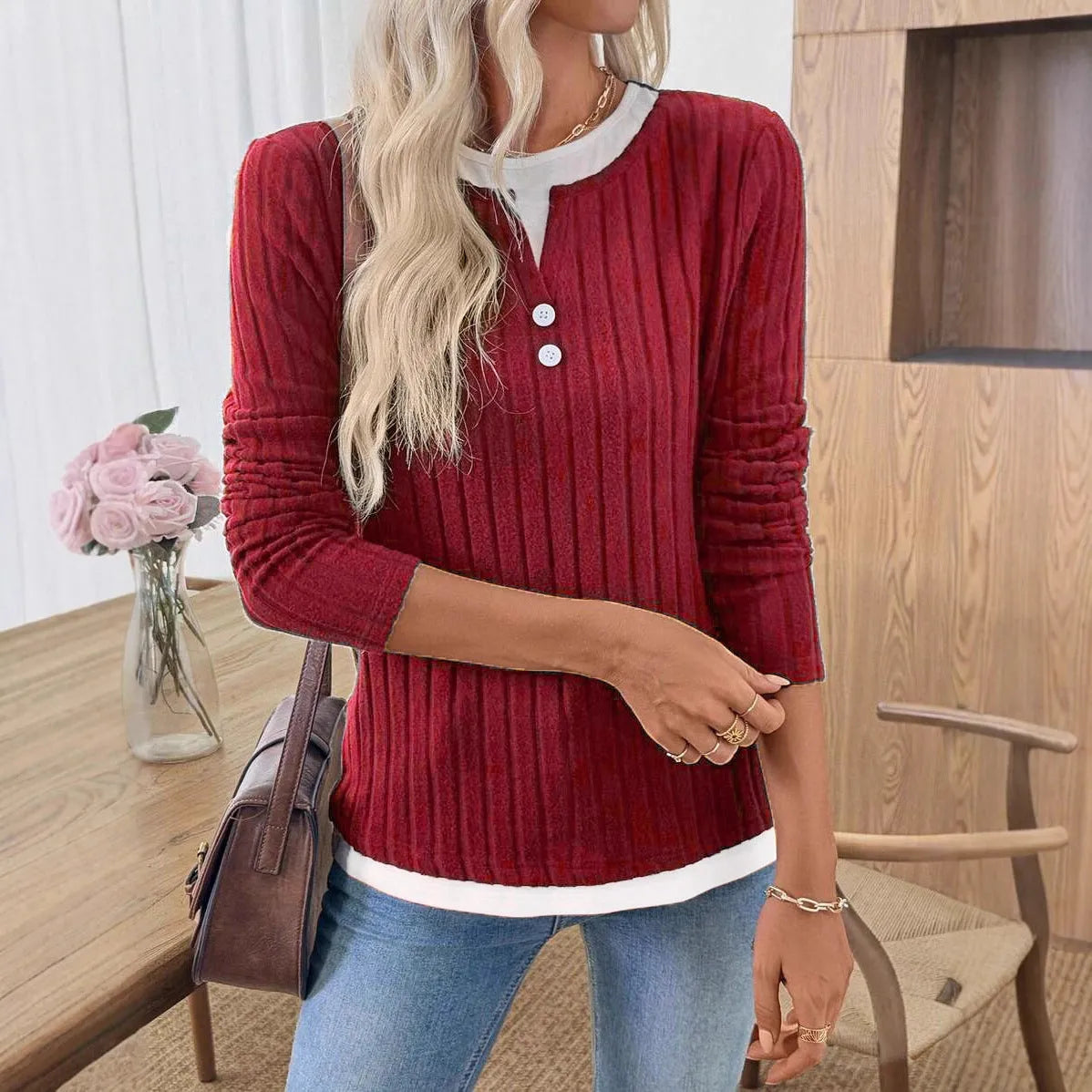 Women's black fake two-piece pullover sweater with a round neck and a button on the shoulder.