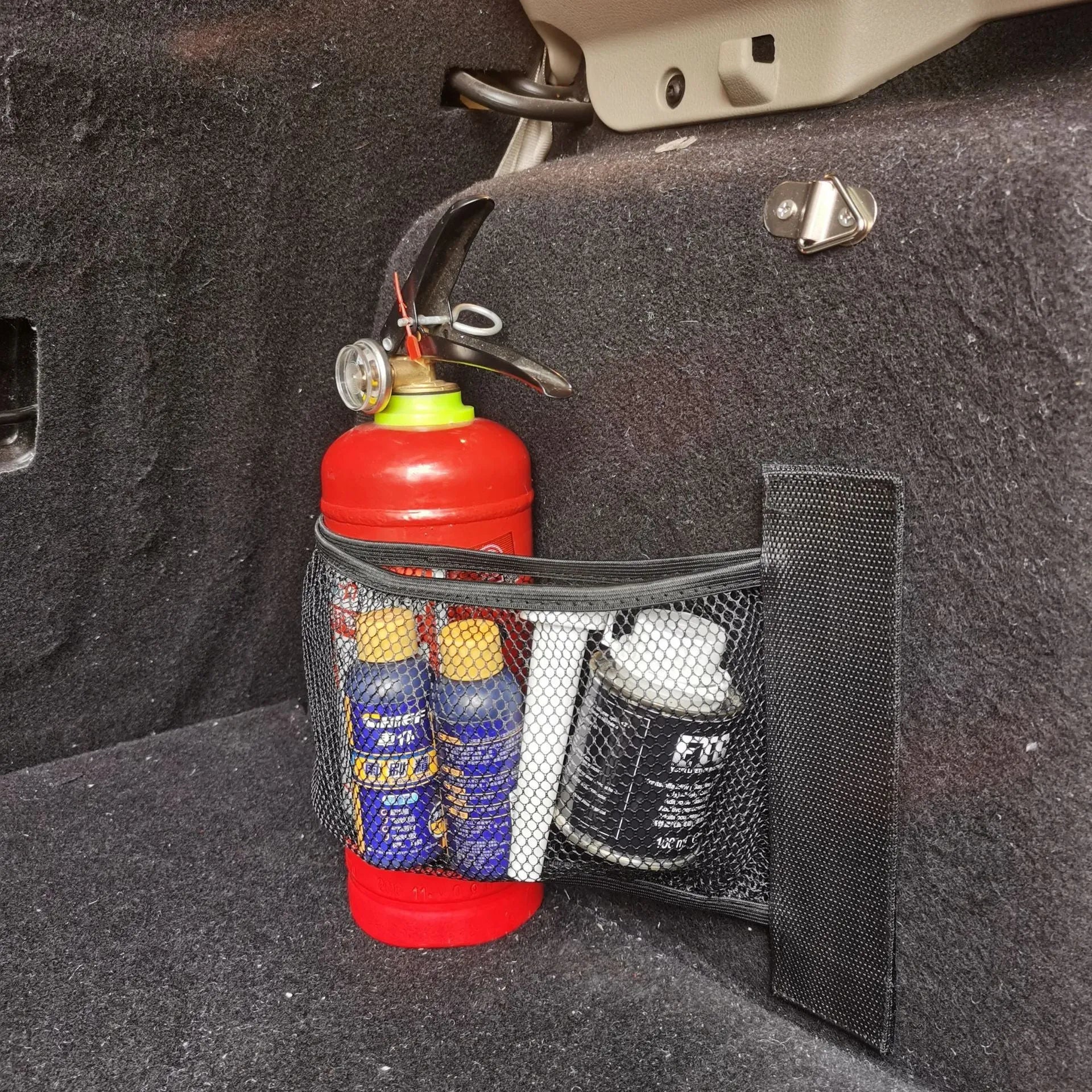 Elasticated grey polyester storage net stretched across a car boot, holding assorted items.