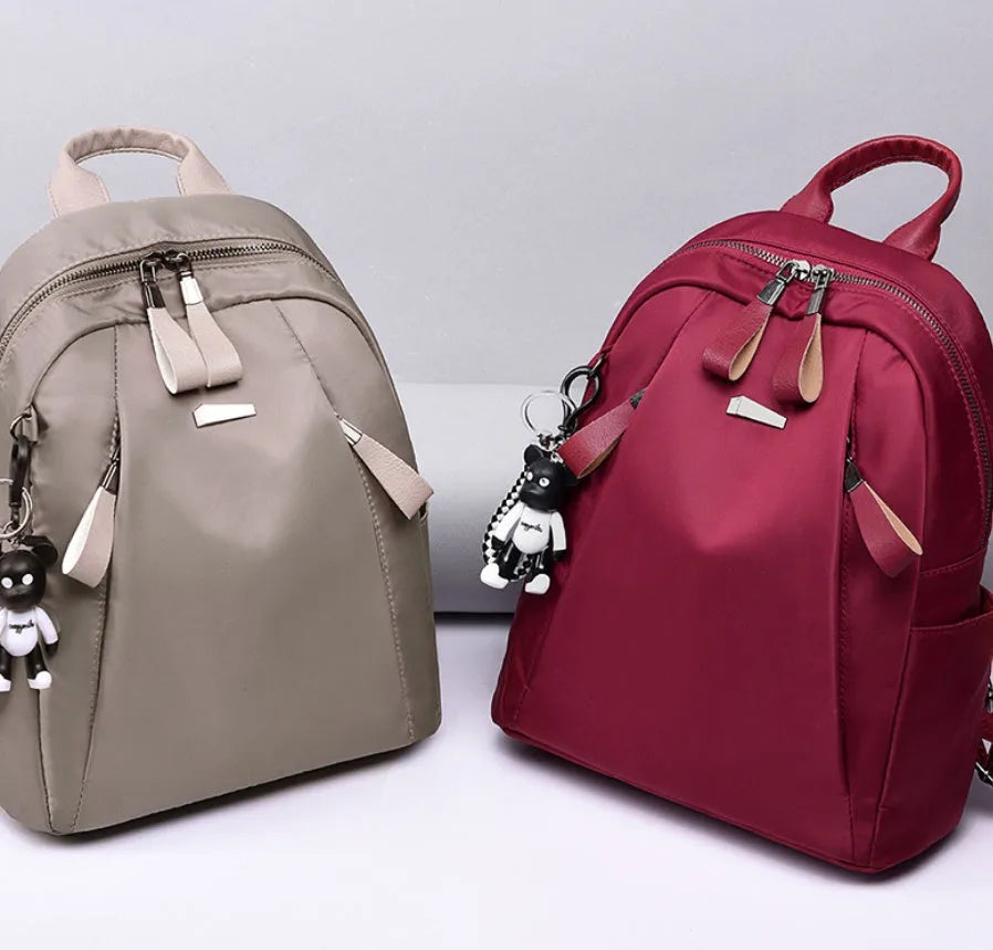 Medium square fashion rucksack in Oxford cloth, shown in red, with internal phone and ID pockets.
