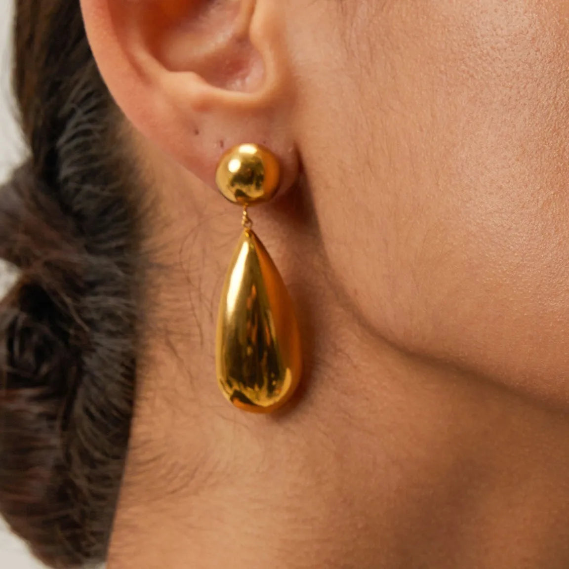 Gold electroplated stainless steel earrings with a geometric hemisphere and water drop pendant.