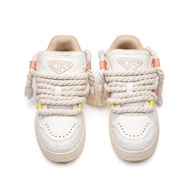 Cream coloured retro lace-up low-top skate shoes on a white background.