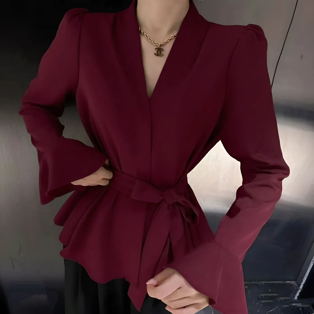 Women's black French-style shirt with an irregular collar and long bell sleeves, showing the tied front closure.