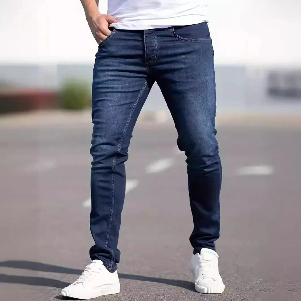 Dark blue men's slim fit casual jeans with a tight leg style and mid waist design.