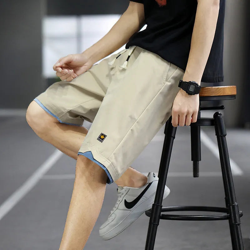 Man wearing green straight-leg loose fit casual beach shorts made from polyester.
