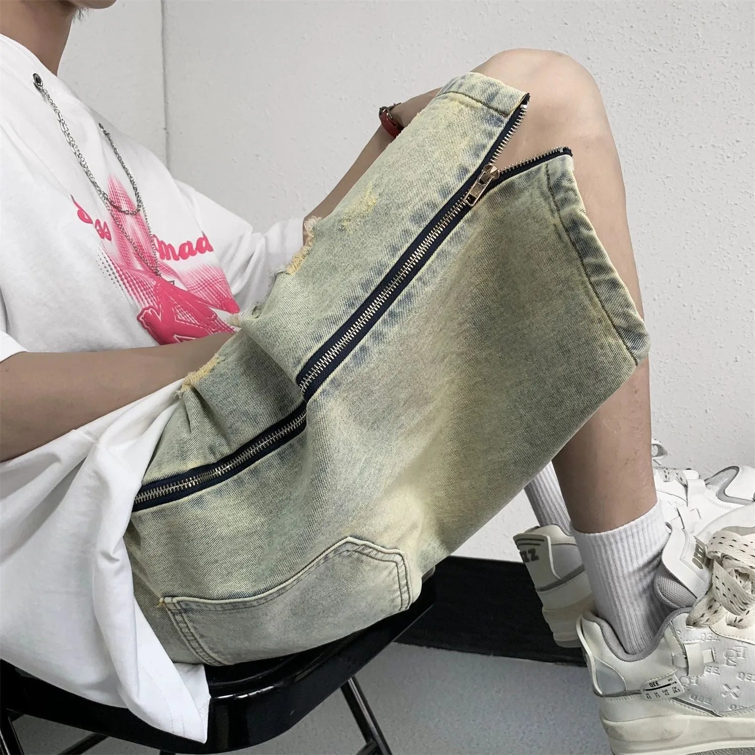 Men's blue denim shorts with loose five-point cut and yellow mud ripped detailing, button fly, straight leg