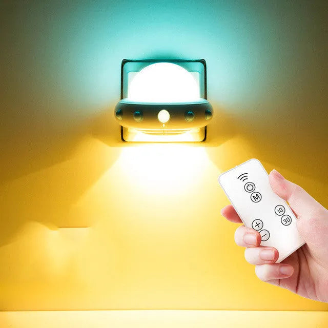Remote control UFO-shaped bedside night light in blue, pink, or white colours.