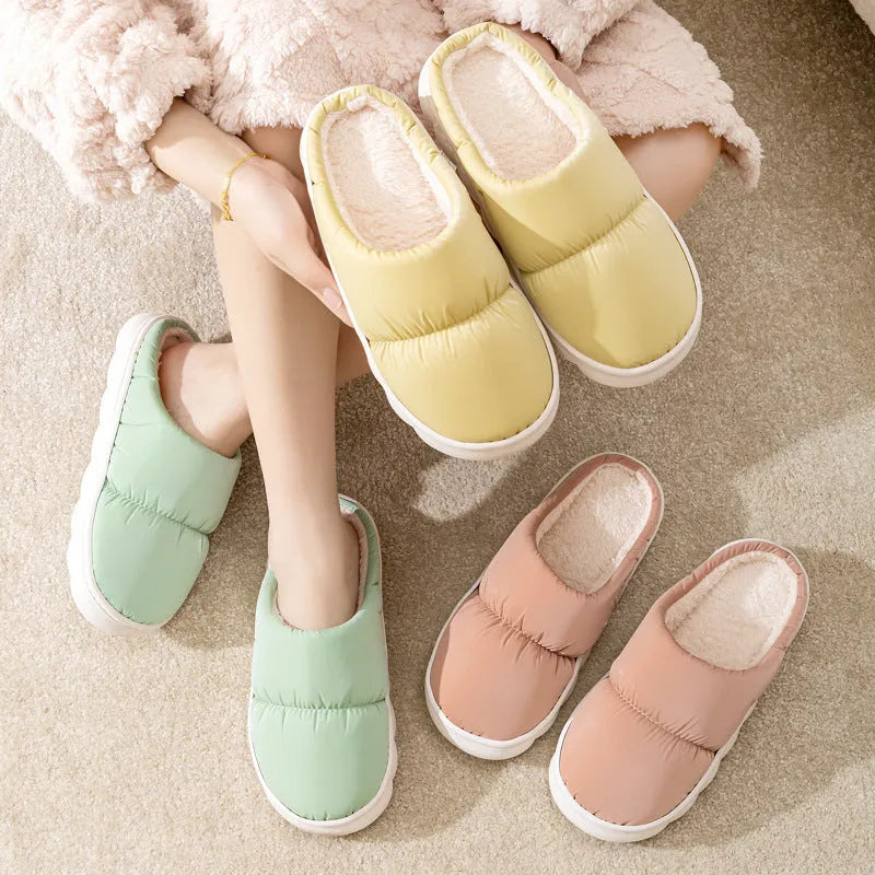 Blue winter house slippers with artificial leather upper, thick rubber sole, and plush lining on a wooden floor.