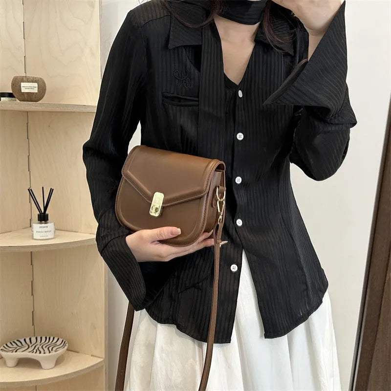 PU leather soft shell messenger bag with clamshell opening in a horizontal square shape.